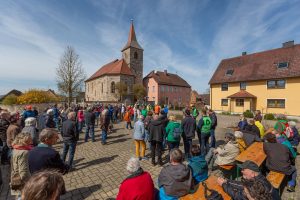 Blick auf die Kirche von Breitenau mit eienr Menschenmenge vor dem GemeinschaftshausBreitenau